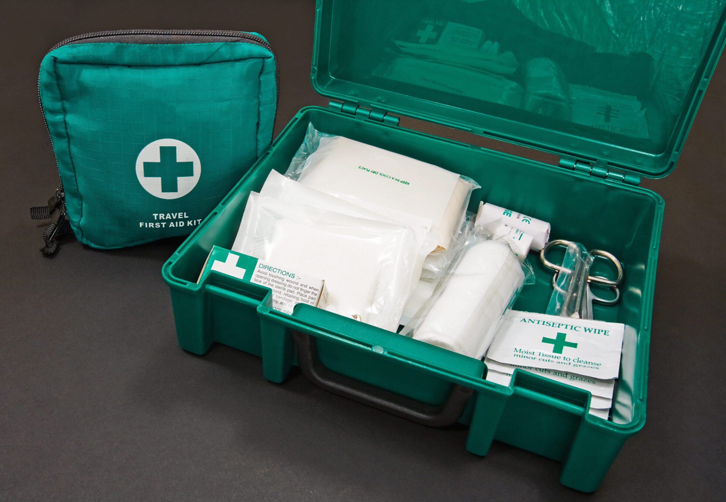A green standard First aid kit, used to provide urgent emergency treatment at school, work or in the home.